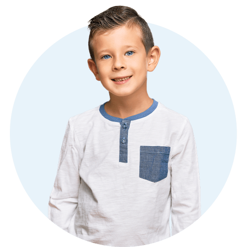 Young boy with a white and blue shirt smiling and looking to the side.